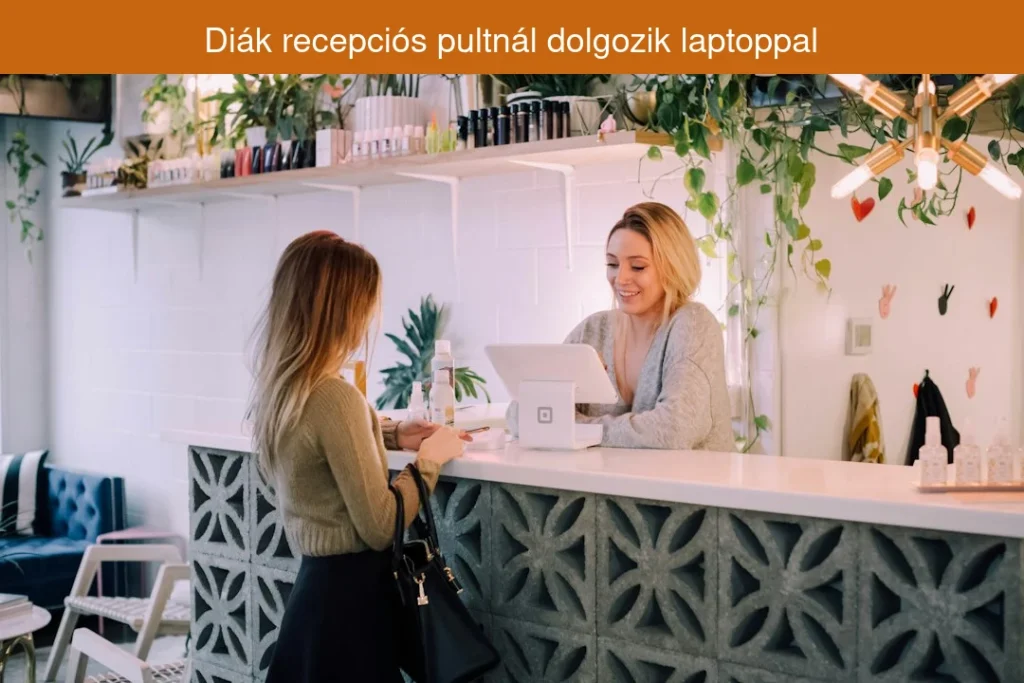 Diák recepciós pultnál dolgozik laptoppal
